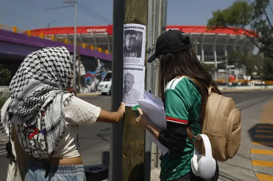 Familias de desaparecidos en México pegan fichas de búsqueda en el Estadio inaugural del Mundial